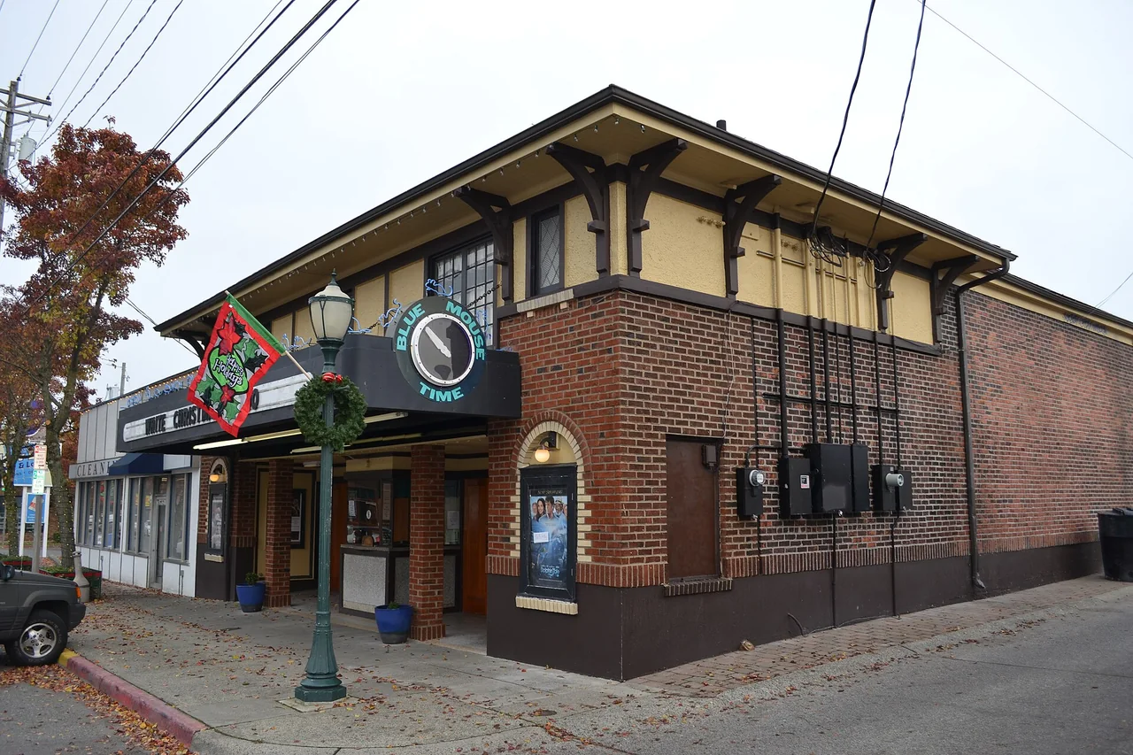 The brick-and-timber corner of the Blue Mouse Theater with its projecting sign and marquee.