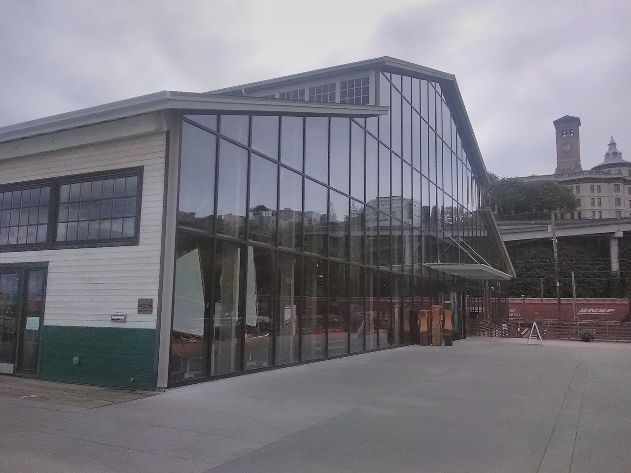The tall glass facade and roof trusses of the Balfour Dock building at Foss Waterway Seaport.