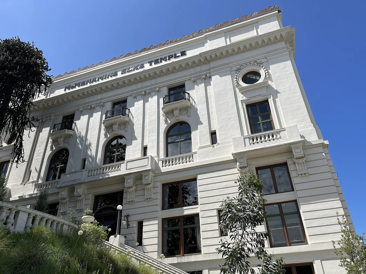 An upward view of the Elks Temple’s pale facade, tall columns and entrance.